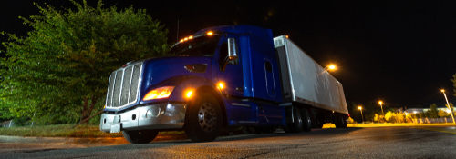 A diesel truck driving on a road at night