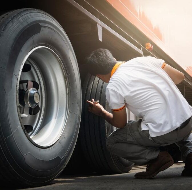 An image of a man inspecting the underside of a diesel truck