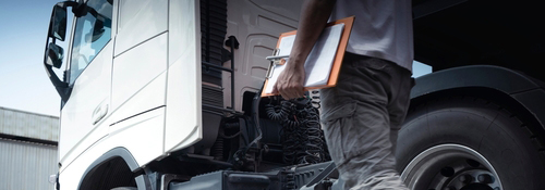 A man with a clipboard outside of a diesel truck